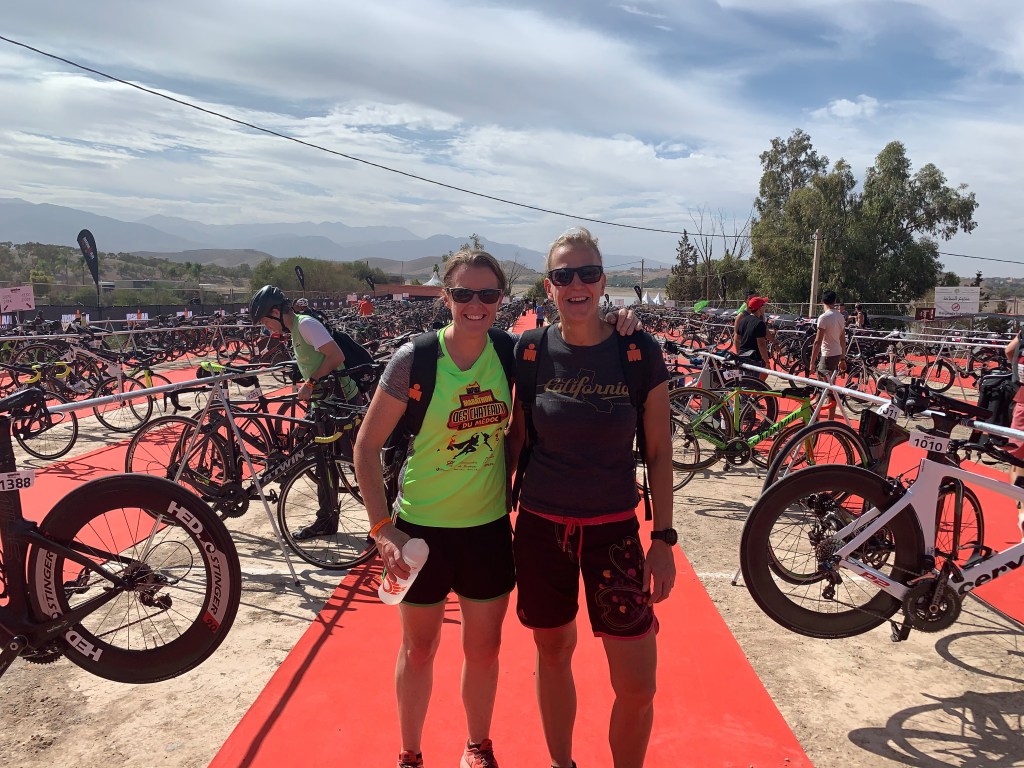 two women in triathlon gear with arms around each other