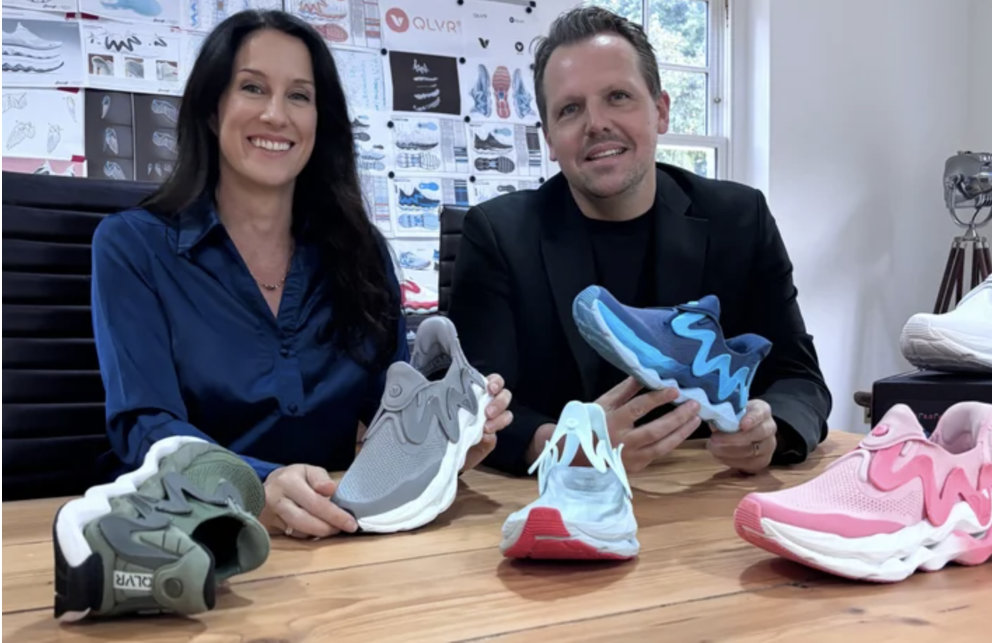 Nicolle Dean and a colleague showcasing various QLVR running slippers, highlighting performance footwear designed specifically for women.
