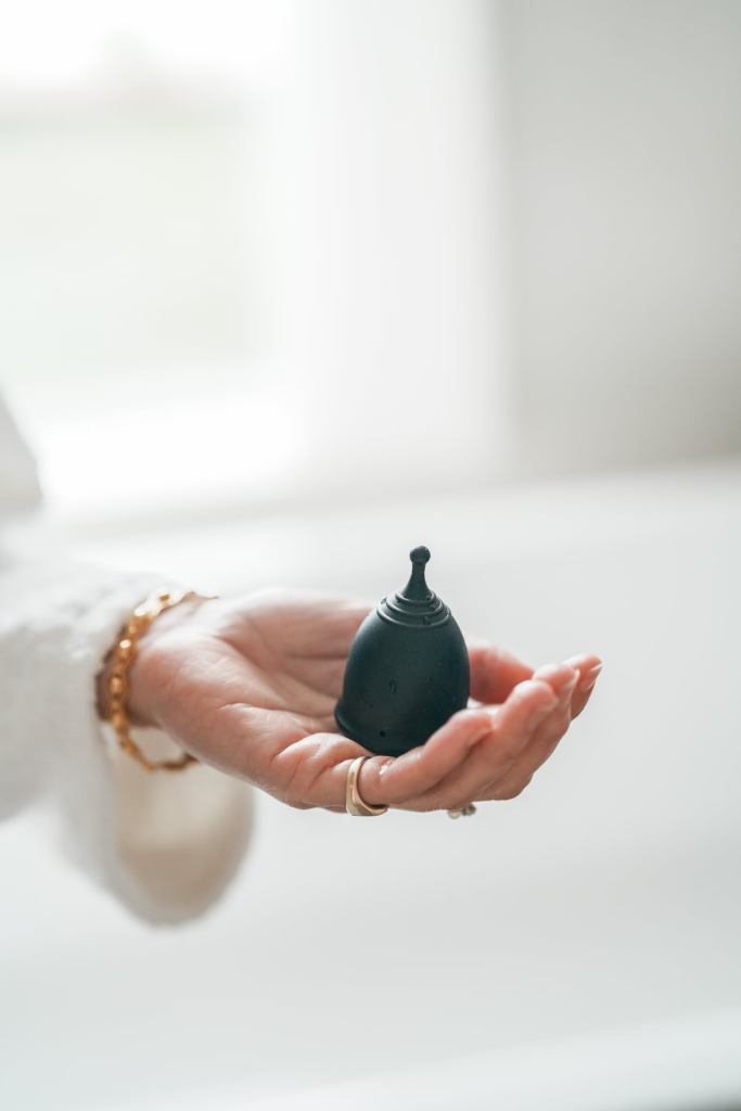 Ladies hand holding a Sea & Flow Menstrual Cup